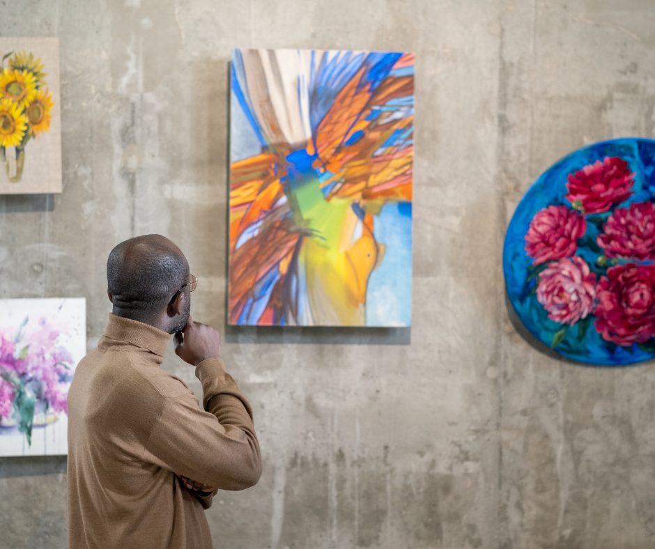 Care after Combat Socials 2024 – 2026-04-15T120151.209 Man viewing colourful abstract artwork in a gallery, celebrating creativity and artistic expression for World Art Day.