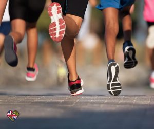 Image of the feet of running, running together as a group towards a goal.